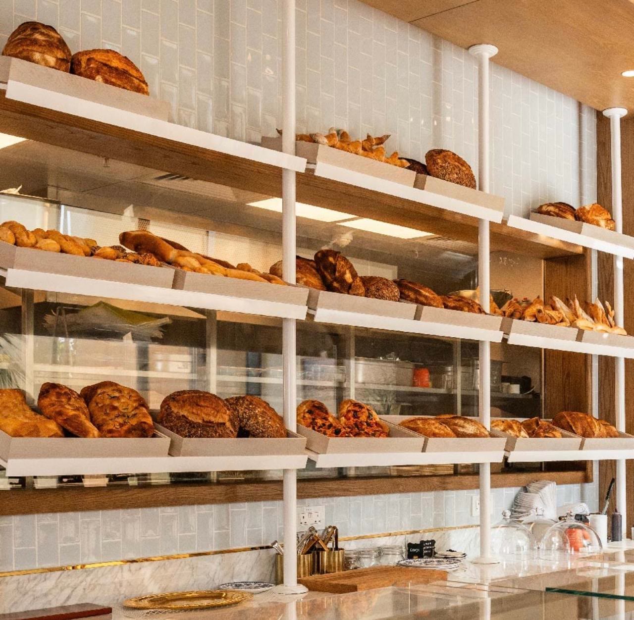 Bianca bakery — timber shelving with fresh bread over marble counters