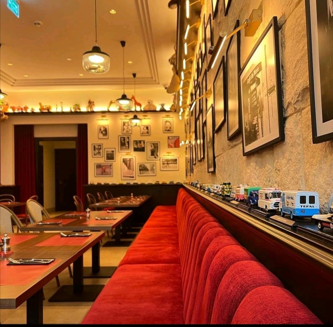 Ferdi restaurant interior — red velvet banquette and gallery wall