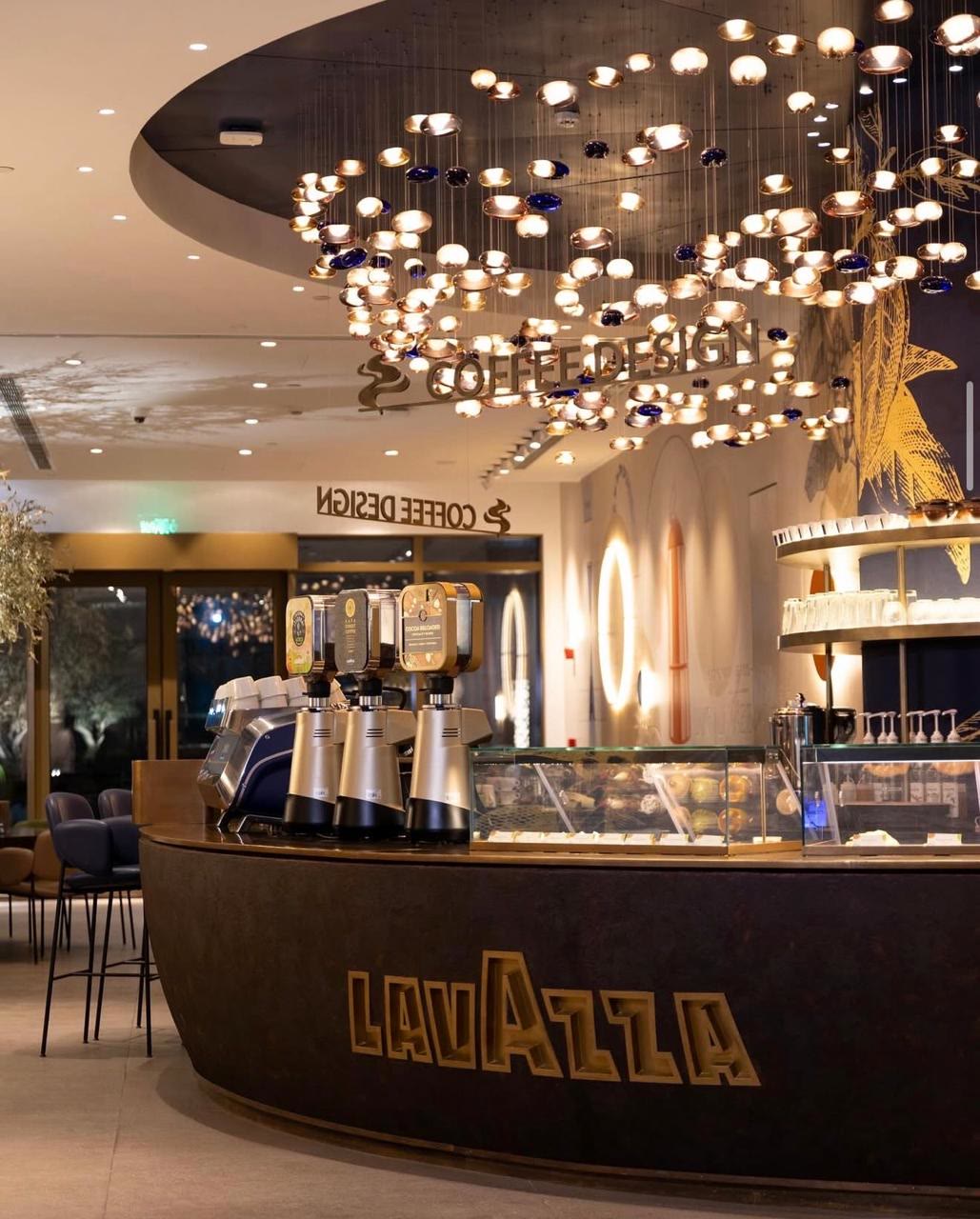Lavazza café — illuminated brand wall with engraved botanical panels