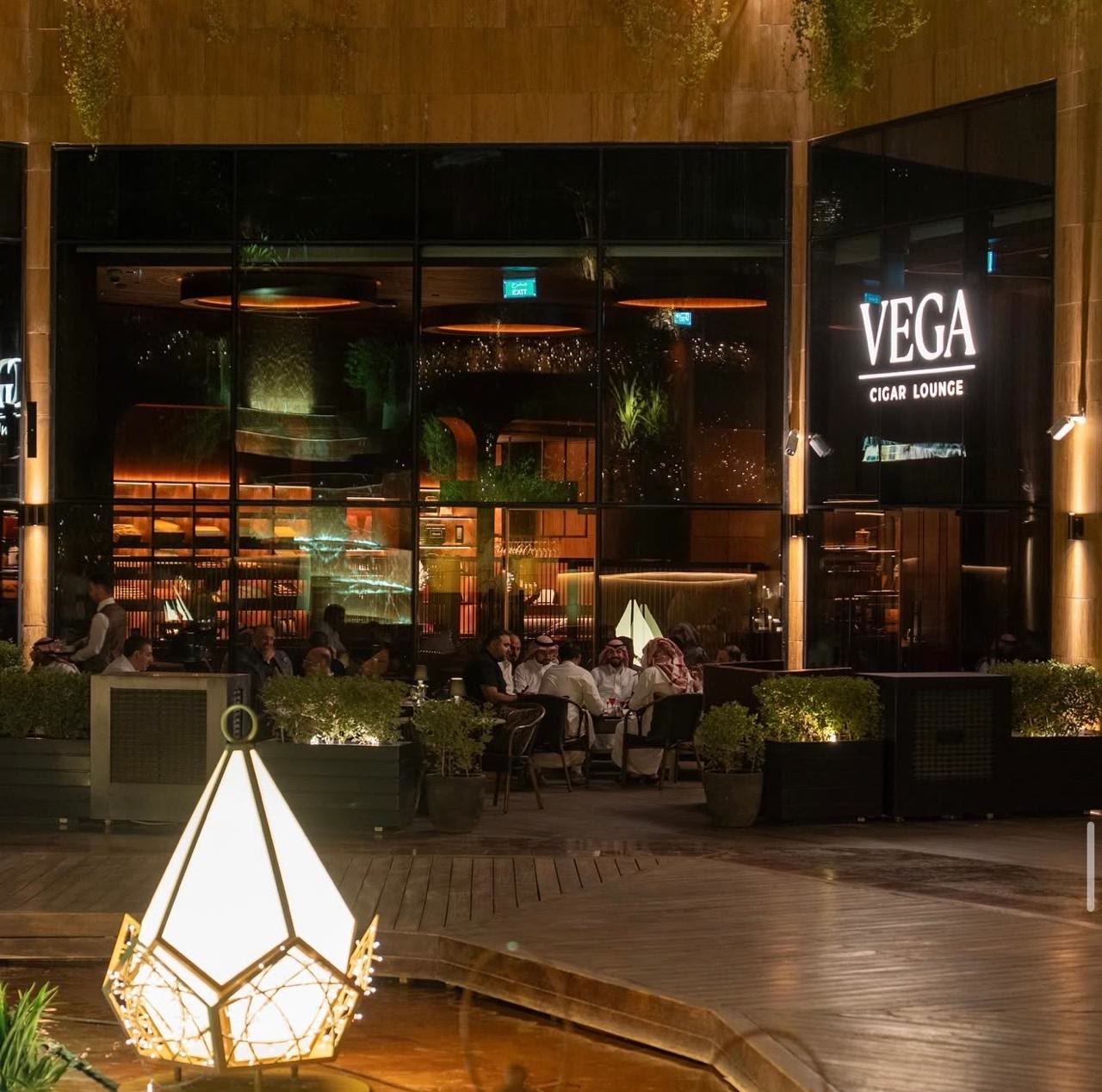 Vega Cigar Lounge — illuminated facade and terrace seating at night